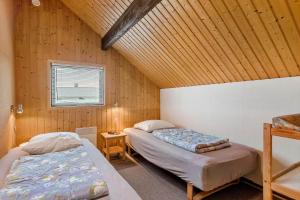 a bedroom with two beds in a room with wooden walls at 601-Hvide-Sande-Bjerregardsvej-375 in Bjerregård