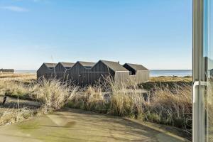 a house on the beach with the ocean in the background at 731-Hvide-Sande-Slusen-31 in Hvide Sande
