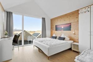 a bedroom with a white bed and a large window at 731-Hvide-Sande-Slusen-31 in Hvide Sande