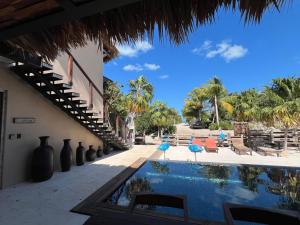 a view of a resort with a swimming pool and palm trees at Flamingo Blue - Casa Boutique - Adults Only in El Cuyo