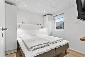 a bed in a room with white walls and a window at 9953-Hvide-Sande-Langsand-212 in Hvide Sande