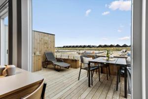a balcony with a table and chairs on a deck at 9953-Hvide-Sande-Langsand-212 in Hvide Sande