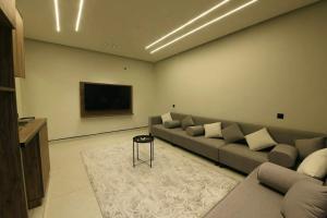 a living room with a couch and a flat screen tv at شقة مشراق in Al-ʿUla