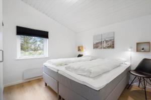 a white bedroom with a large bed with a window at 354-Hvide-Sande-Fyrmarken-24 in Hvide Sande +43 photos