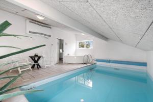 a bathroom with a swimming pool and a tub at 354-Hvide-Sande-Fyrmarken-24 in Hvide Sande