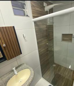 a bathroom with a sink and a glass shower at ML Integra Mix kitnets in Maceió