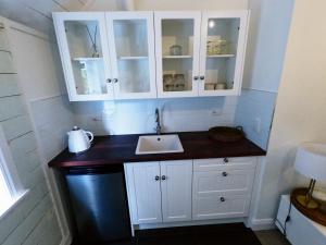 a bathroom with a sink and white cabinets at Pinegrove Cottage - Greytown Getaway in Woodside