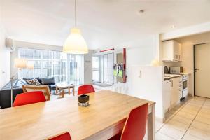 a kitchen and living room with a wooden table and red chairs at 770-Hvide-Sande-Norregade-4-B in Hvide Sande