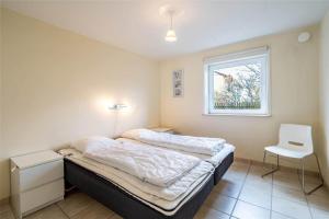 a small bedroom with a bed and a window at 770-Hvide-Sande-Norregade-4-B in Hvide Sande