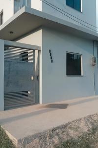 a white garage door on a white building at Loft Marajó Superior in Soure