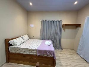 a small bedroom with a bed and a window at Loft Marajó Superior in Soure
