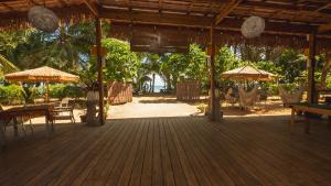a wooden deck with umbrellas and tables and chairs at Playa Bluff Lodge in Bocas Town