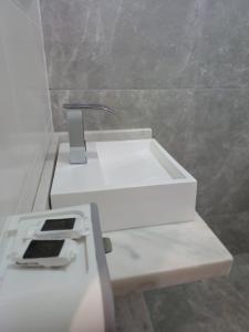a white sink in a bathroom next to a wall at Riviera Sanary 1208 Nova Almeida in Serra
