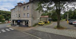 a yellow car parked in front of a building at APaRTAMENT MOUTAIN SKY in Świeradów-Zdrój