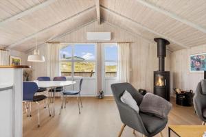 a living room with a table and chairs and a fireplace at 5526-Hvide-Sande-Baunebjergvej-29-A in Havrvig