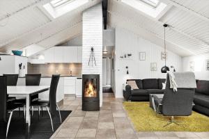 a living room with a fireplace and a table with chairs at 6600-Hvide-Sande-Bjerregaardsvej-128 in Bjerregård