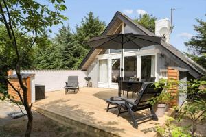 a patio with a table and chairs and an umbrella at 303-Hvide-Sande-Fyrmarken-36 in Hvide Sande