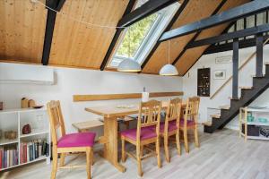 a kitchen and dining room with a wooden table and chairs at 303-Hvide-Sande-Fyrmarken-36 in Hvide Sande +24 photos