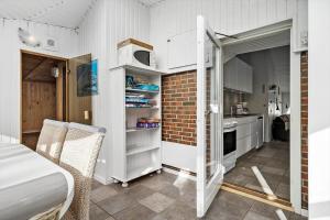 a kitchen with white cabinets and a brick wall at 6600-Hvide-Sande-Bjerregaardsvej-128 in Bjerregård