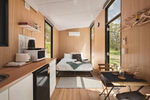 a bedroom in a tiny house with a bed at Maroota Greens SKY by Tiny Away in Maroota