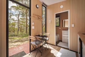 a room with a table and chairs in a house at Maroota Greens SKY by Tiny Away in Maroota