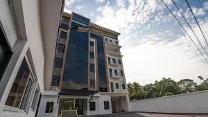 a tall building with a sky in the background at Hotel Harvest Retalhuleu in Santa Cruz Muluá