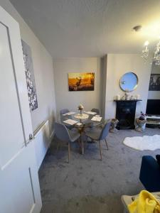 a living room with a table and chairs and a fireplace at Amazing Central Windsor Flat Contractors welcome in Windsor