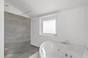 a white bathroom with a tub and a window at 621-Hvide-Sande-Dortheasvej-8 in Bjerregård +23 photos