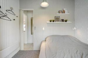 a bedroom with a bed and a white wall at 621-Hvide-Sande-Dortheasvej-8 in Bjerregård