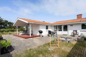 a backyard with a house and a playground at 621-Hvide-Sande-Dortheasvej-8 in Bjerregård