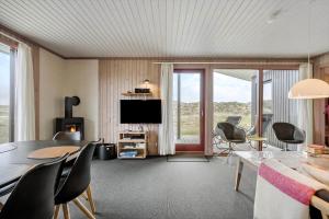 a living room with a table and chairs and a television at 467-Hvide-Sande-Tingodden-212 in Hvide Sande