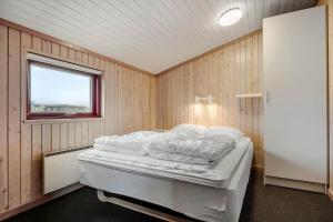 a bedroom with a bed in a room with a window at 467-Hvide-Sande-Tingodden-212 in Hvide Sande