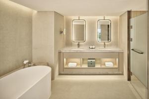 a bathroom with two sinks and a tub and two mirrors at The Westin Seoul Parnas in Seoul