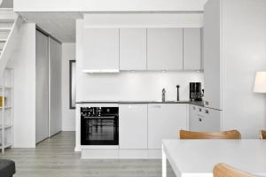 a white kitchen with white cabinets and a table at 774-Hvide-Sande-Norregade-2-nr-7 in Hvide Sande