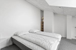 a bedroom with white walls and a bed with white sheets at 774-Hvide-Sande-Norregade-2-nr-7 in Hvide Sande