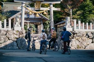 a group of people riding bikes in front of a temple at 八百熊川 Yao-Kumagawa in Kumagawa