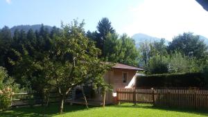 a small house with a wooden fence in a yard at Ferienwohnung Hauser in Söll