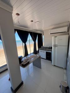 a kitchen with a view of the beach at Cantinho Sol e Sal in Guarapari