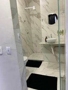a bathroom with a shower and a toilet and a sink at Cantinho Sol e Sal in Guarapari
