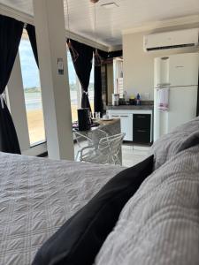 a bedroom with a bed and a view of a kitchen at Cantinho Sol e Sal in Guarapari