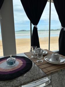 a table with a view of the beach at Cantinho Sol e Sal in Guarapari +5 photos