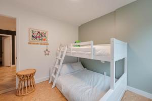 a white bunk bed in a room with a stool at Unité 17 - Ski-in Ski-out in Beaupré