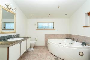 a bathroom with a tub and a sink and a toilet at 439-Hvide-Sande-Tingodden-120 in Hvide Sande +22 photos
