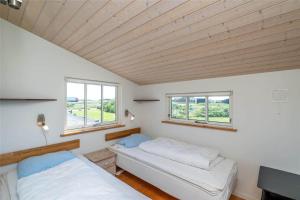 a bedroom with two beds and two windows at 439-Hvide-Sande-Tingodden-120 in Hvide Sande