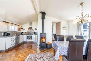 a kitchen and dining room with a table and a fireplace at 439-Hvide-Sande-Tingodden-120 in Hvide Sande