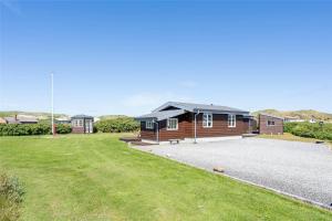 a house with a gravel driveway in front of it at 439-Hvide-Sande-Tingodden-120 in Hvide Sande