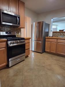 a kitchen with a stove and a stainless steel refrigerator at Quiet Desert Oasis off Swan Rd in Tucson