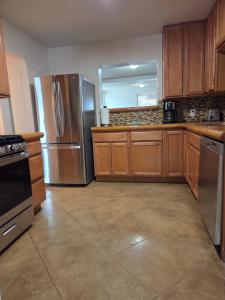 a kitchen with stainless steel appliances and wooden cabinets at Quiet Desert Oasis off Swan Rd in Tucson +8 photos