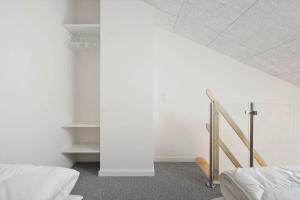 a white room with two beds and a staircase at 777-Hvide-Sande-Norregade-2-nr-2 in Hvide Sande