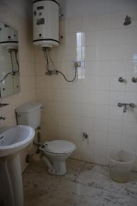 bagno sporco con servizi igienici e lavandino di AbodeHome Cottage a Manāli